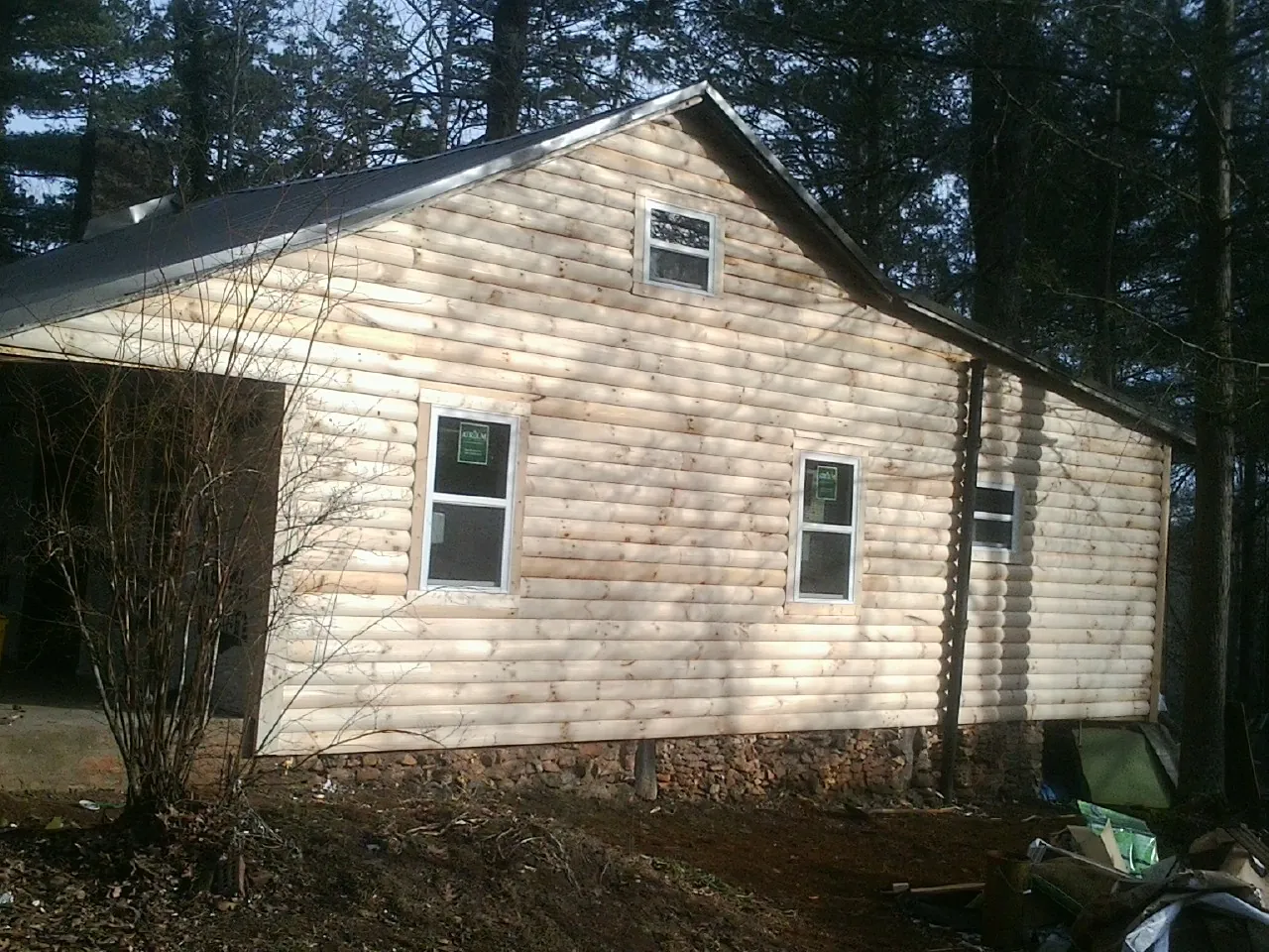 New log siding and dark metal roofing on a gable end in Bonifay